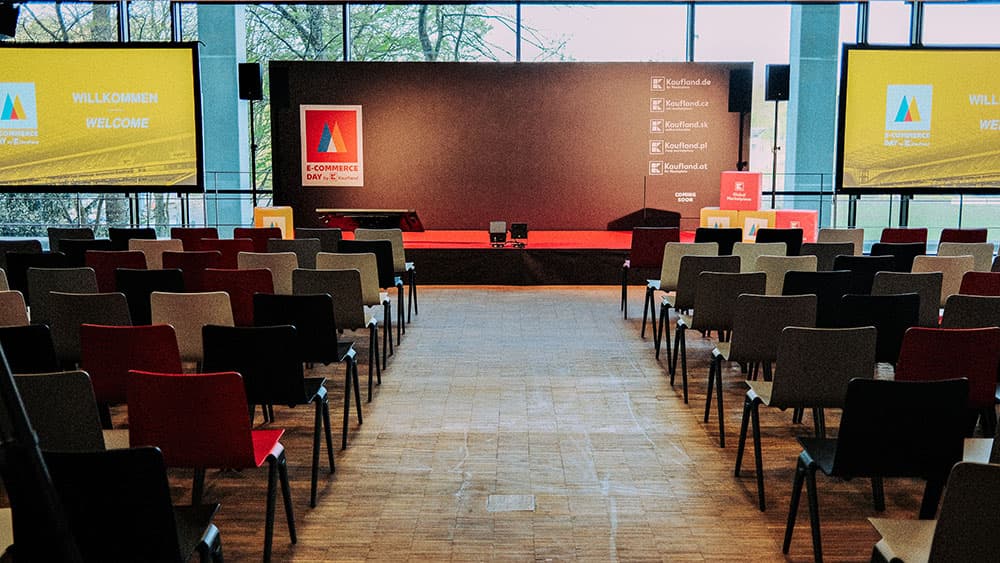 Bühne mit mehreren Leinwänden und Bestuhlung